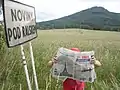 Ortsschild, Zeitung und der Berg Ralsko