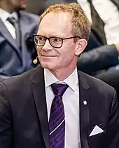 Foto eines Mannes mit Brille und Mikrofon