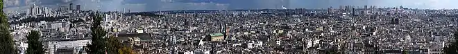 Farbiges Panorama von Paris mit vielen Hochhäusern im linken und rechten Hintergrund.