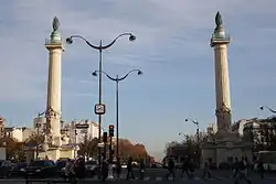 Blick auf die Säulen der Barrière du Trône und der Avenue du Trône, vom Place de la Nation (im Hintergrund der Cours de Vincennes)