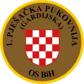 Soldat des 1.&nbsp;Infanterie-(Garde-)Regiments OS&nbsp;BiH (Traditionsregiment HVO) mit seinem Partner von der US-Armee während eines Manövers auf dem Truppenübungsplatz „Eugen Kvaternik“ (2012) und Ärmelabzeichen der Einheit.