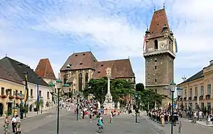 Perchtoldsdorfer Marktplatz: links die Martinskapelle, mittig die Pfarrkirche, rechts der Wehrturm und im Vordergrund die Dreifaltigkeits-(Pest-)säule