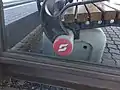 Ein weißer Pflatsch auf rotem Hintergrund, auf einer alten Bank am Saalfeldner Bahnhof, Februar 2019