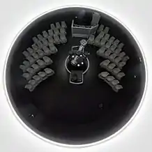 Kuppelsaal eines Planetariums mit unidirektionaler Sitzanordnung. In der Mitte befindet sich das Projektionssystem, bestehend aus einem Sternprojektor und einer Fulldome-Video-Anlage.