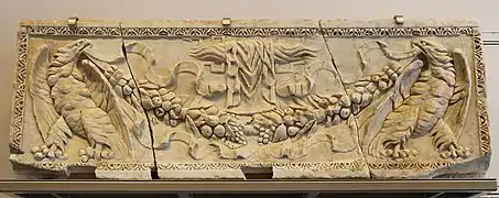 Marmorblock mit Adlern, die eine Girlande halten. Erste Hälfte des 2. Jh. n.&nbsp;Chr. Das Ursprungsgebäude ist unbekannt. Es wurde im Chor der Kirche Sainte-Marie-de-la-Major wiederverwendet.
