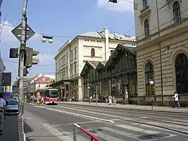 Jetzige Hauptfassade an der Havlíčková ulice. Im Hintergrund das ursprüngliche Ankunftsgebäude, im Vordergrund rechts das Gebäude der ehemaligen Bahnhofsgaststätte