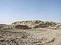 Ansicht der Pyramidenruine von Nordosten. Im Vordergrund Teile der Mauer des Werkstattgebäudes