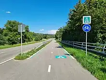 Zeigt den Eingang des Radschnellweges RS 4 in Reichenbach an der Fils, mit Verkehrszeichen 350.1 und 237, zwei streifig, daneben eine Landstraße. Beides getrennt mithilfe einer Leitplanke.