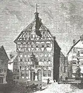 Um 1865: Mit Doppelportal, Rundbogenfenstern im EG und Baldachin überm Balkon