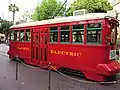 Roter Straßenbahnwagen mit Mitteleinstieg und goldgelbener Beschriftung PACIFIC ELECTRIC