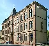 Friedrich-Wilhelm-Straße 58, ehemaliges Schul­haus von St. Barbara; dreigeschossiger neugotischer Bau mit Sandsteinfassade, 1881, Erweiterung 1894, Aufstockung 1902.