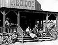 Roy Rogers (rechts an der Säule lehnend) mit anderen Schauspielern in den 1950er Jahren. Der Red Dog Saloon brannte im April 1966 ab.