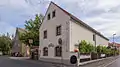 Wohnstallhaus (mit eingeschossigem Anbau), Seitengebäude (Wohnstallhaus) und Scheune eines Dreiseithofes sowie Reste der Hofmauer