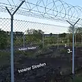 Die Dreifachumzäunung mit einem äußeren und einem inneren Streifen