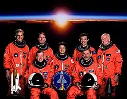 v. l. n. r. vorne: Steven Lindsey, Curtis Brown; hinten: Scott Parazynski, Stephen Robinson, Chiaki Mukai, Pedro Duque und John Glenn