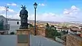 Skanderbegstatue; im Hintergrund die Wallfahrtskirche SS. Cosma e Damiano