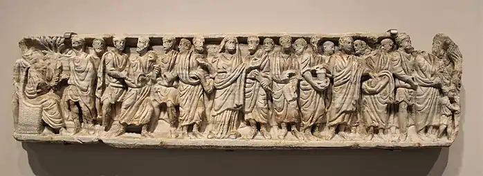 Teil eines Marmorsarkophags, 4. Jh. Im Gegensatz zur üblichen Darstellung der Zeit sind die Figuren hier nicht durch Bäume getrennt. Das Fragment wurde bei einem Narbonner Haus wieder verwertet.