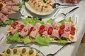 Schinkenrollen aus Pressschinken auf grünen Salat