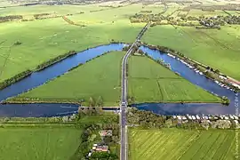 Flußbogen mit ehemaligem Schleusenhaus (hinten)  und Schleusenkanal (vorn)
