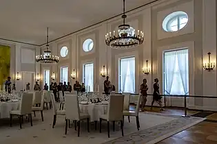 Großer Saal mit Tischen für ein Dîner