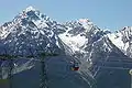 Piz Pisoc mit Schnee, vom Motta Naluns aus (höchster Gipfel im linken Bereich). Hinter der Gondel die Val Zuort (klassischer Aufstieg).