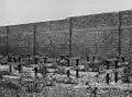 Reste der Essensbänke für die Gefangenen (um 1928) mit Gefängnismauer im Hintergrund