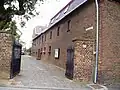 Der Steinfelderhof, im Hintergrund das Pfarrhaus