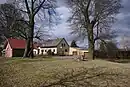 Platz des Dorfgerichts bzw. der Bauernversammlung (baumumstandener Kreis mit Mahlstein im Mittelpunkt)
