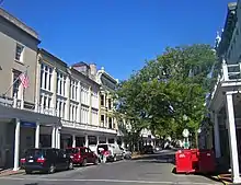 Eine Straße mit Geschäften und Holzdächern über den Gehwegen