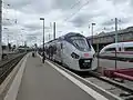 Regionalverkehrstriebwagen und ein deutscher ICE (rechts)