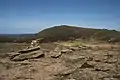 Der Gipfelcairn des A’ Chòinneach, im Hintergrund der Bynack More, auf dem Grat rechts erkennbar die Barns of Bynack