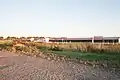 Die Hühnerfarm sieht man während einer Autofahrt (1:07:11)