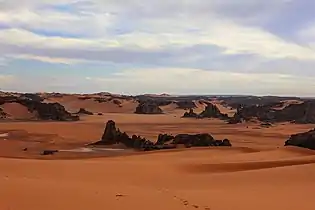 Östliche Abhänge des Tassili Tadrart in Dünen auslaufend