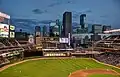Target Field vor der Skyline. Im rechten Hintergrund das Target Center, die Spielstätte der Minnesota Timberwolves aus der National Basketball Association (Mai 2014).