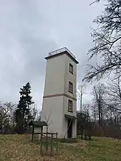 Das Landschaftsphoto zeigt zwischen Baumzweigen den Turm der Telegrafenstation 28