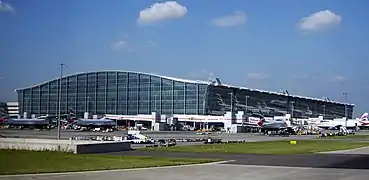 Planes congregate by a building.