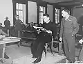 Der polnische Priester Theodore Korcz (links) liest am 22.&nbsp;November 1945 im Beisein von Hauptankläger Denson aus den Malariaprotokollen vor