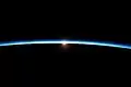 Von der ISS in Ebene des Terminators aus gesehen erleuchtet gestreutes Licht die Erdatmosphäre
