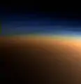 Echtfarbaufnahme der oberen Titan­atmosphäre. In der blauen Dunst­schicht brechen Methan­moleküle auf, darunter liegt der orange­farbene Dunst. Aufnahme aus 9500&nbsp;km Ent­fer­nung, die Auf­lösung beträgt ca. 400&nbsp;m pro Pixel (Cassini, 2005)