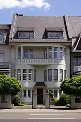 Katharinenufer 5: Reihenvilla im Reformstil mit zwei nahezu halbrunden Standerkern, 1909, Architekt C. Kokke