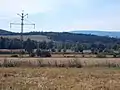 Alte, heute mit Drehstrom betriebene Bahnstrom-Freileitung in Schlesien: Zuerst verwendeter Masttyp mit zwei …