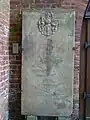 Grabtafel links neben dem Seiteneingang der Kirche