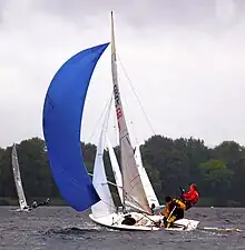 Jolle unter Spinnaker, mit Vorschoter im Trapez