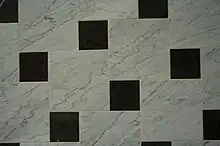 Bodenbelag aus Carrara-Marmor und Impala (dunkle Platten)