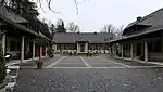 Der Vorhof mit dem ehemaligen Bedienstetengebäude (rechts) sowie den früheren Pferdeställen und Garagen (links).