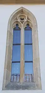 Frühgotisches Maßwerkfenster an der Nordfassade mit zwei Nonnenköpfen und Vierpass