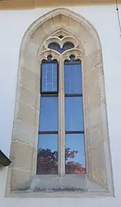 Spätgotisches Maßwerkfenster an der Nordfassade mit zwei Nonnenköpfen und Herz