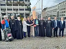 Vertreter von sieben Religonsgemeinschaften bei der Enthüllung der Friedenstaube vor dem Neuen Rathaus in Linz.