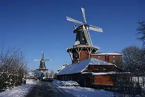 Deichmühle im Winter, im Hintergrund die Frisia-Mühle