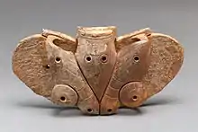 Ein Objekt aus Walross-Elfenbein, das mit flügelartigen Dekorationen verziert wurde.